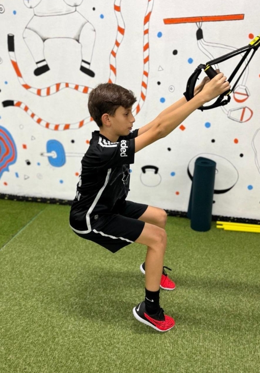 Football players training intensely on a professional pitch at dusk